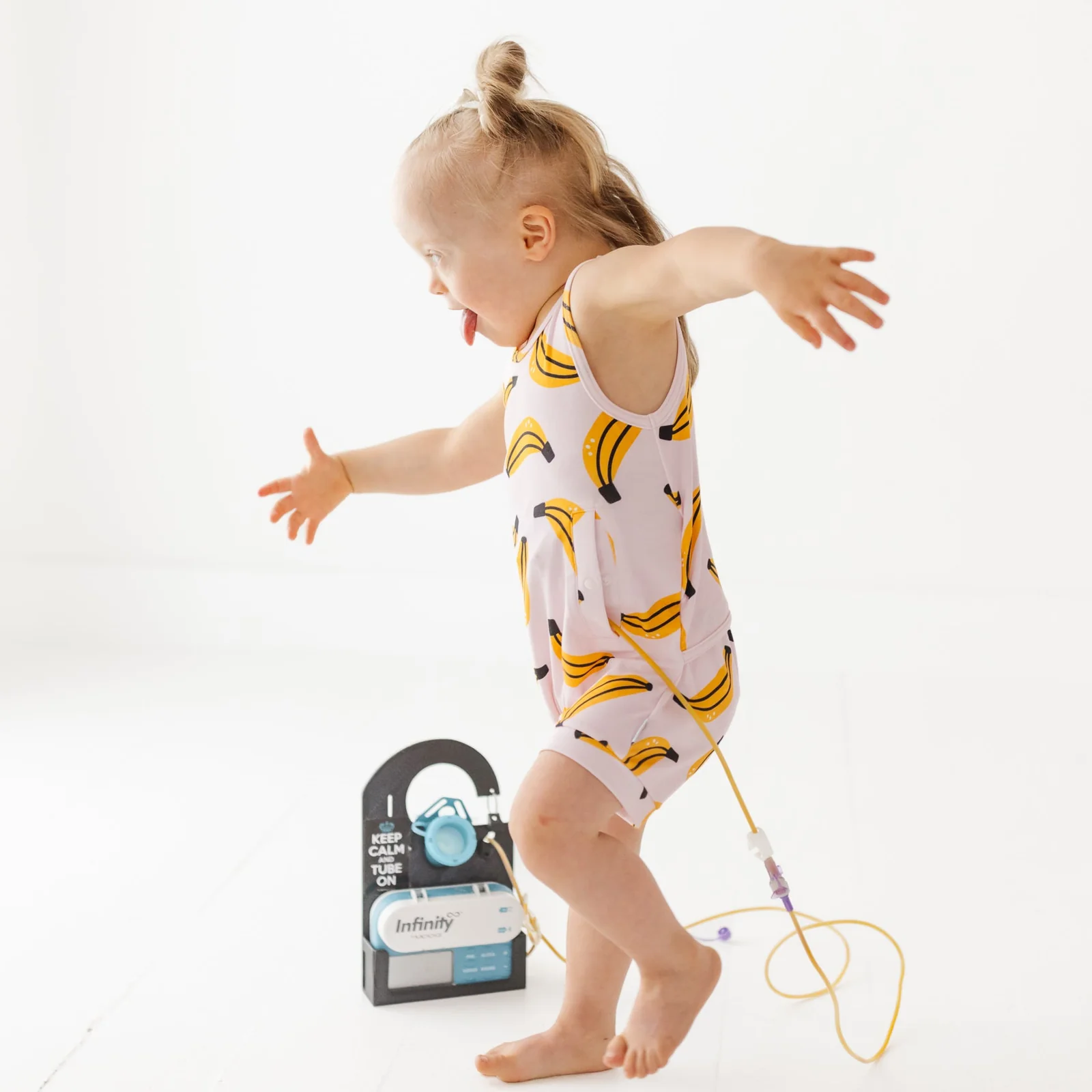 Toddler runs whilst wearing tube feeding romper